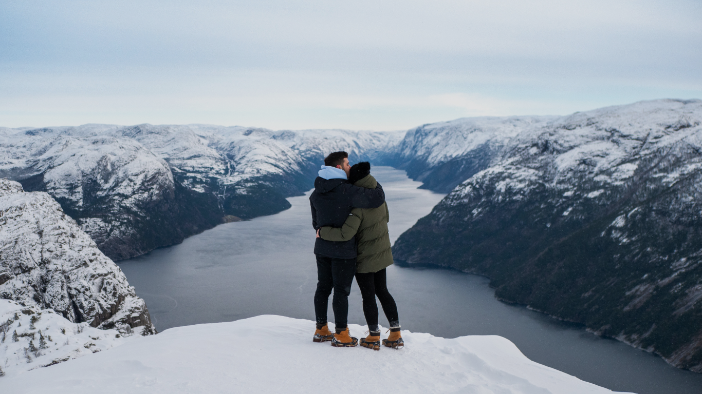 Couple devant un fjord enneigé